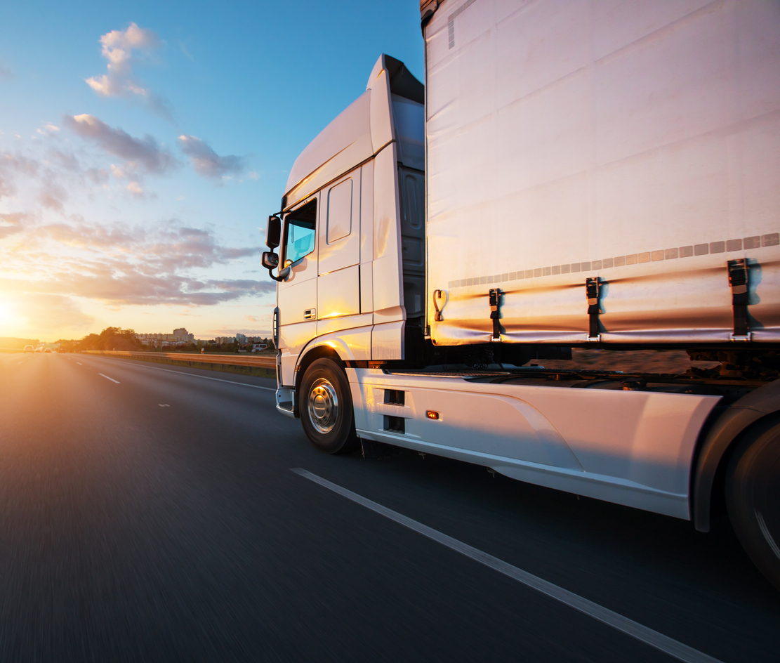 Semi truck driving down the road at sunset | Road Transport Australia | Tasman Logistics Services