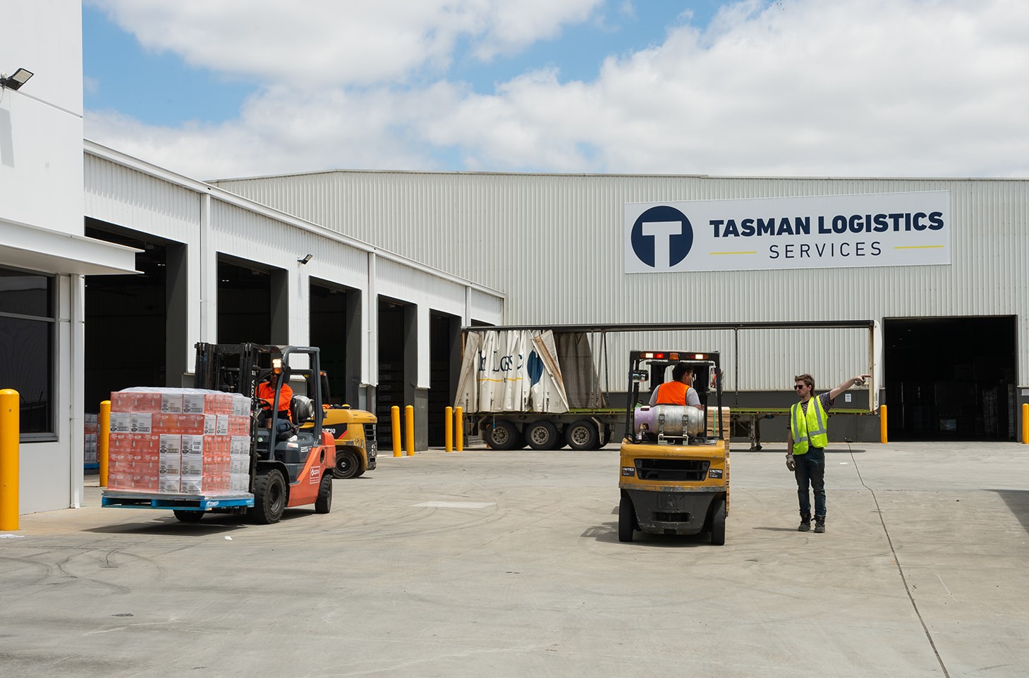 Men in front of a warehouse operating fork trucks | Flex Warehouse Space | Tasman Logistics Services