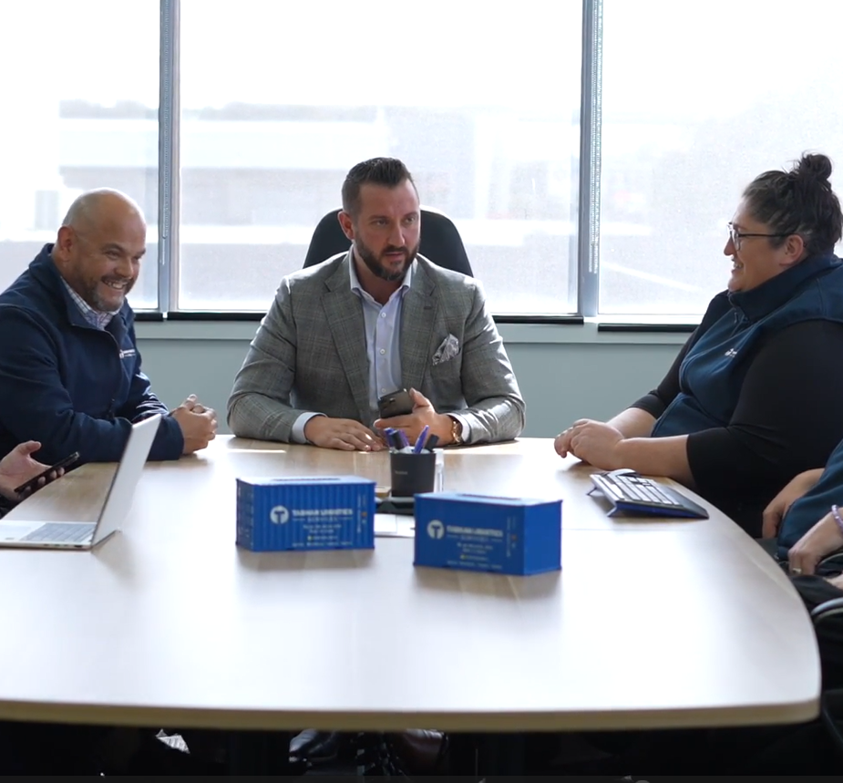 Five people sitting around a table with laptops | Project Logistics | Tasman Logistics Services
